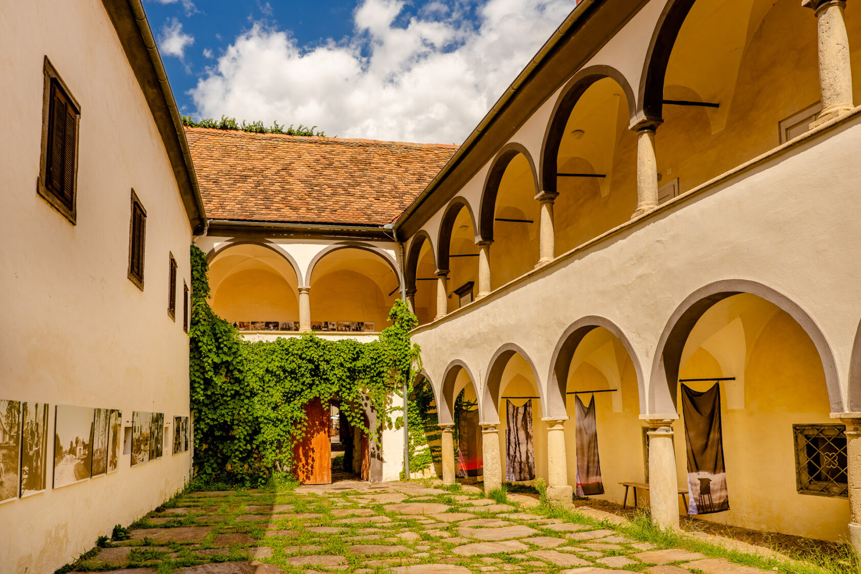 Innenhof eines historischen Gebäudes mit Arkadengängen und Weinreben in der kleinen historischen Stadt Bad Radkersburg.